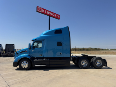 Peterbilt 579 tractor in blue, side view showing sleeper cab and chrome wheels.