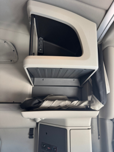 Truck interior console with open storage compartment and control panel; no legible labeling visible.