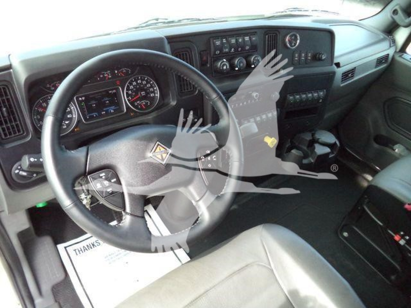 Interior view of a 2025 International MV truck cabin showing steering wheel, dashboard, gauges, and center console.