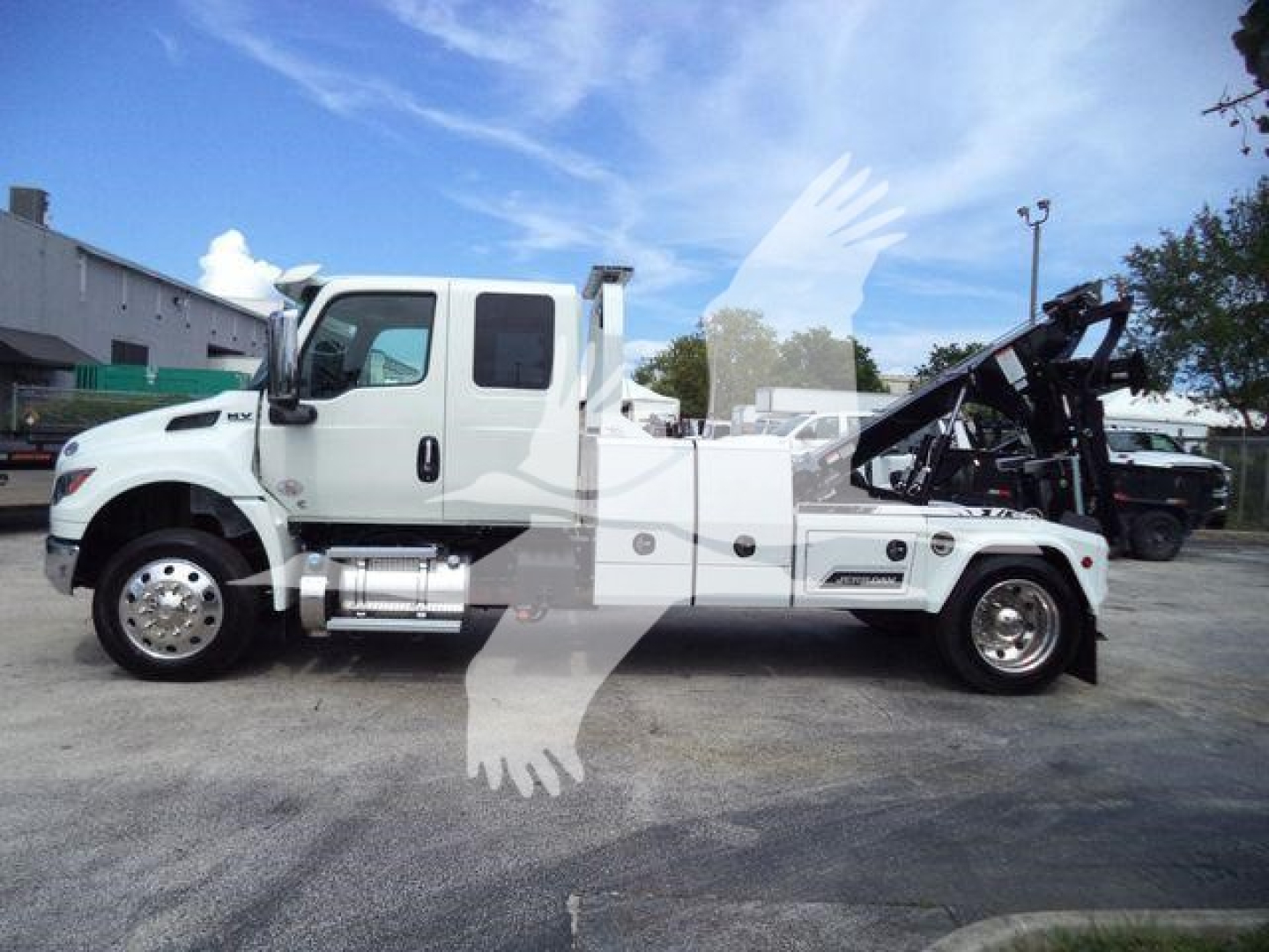 International MV tow truck side view showing mounted winch and service compartments.