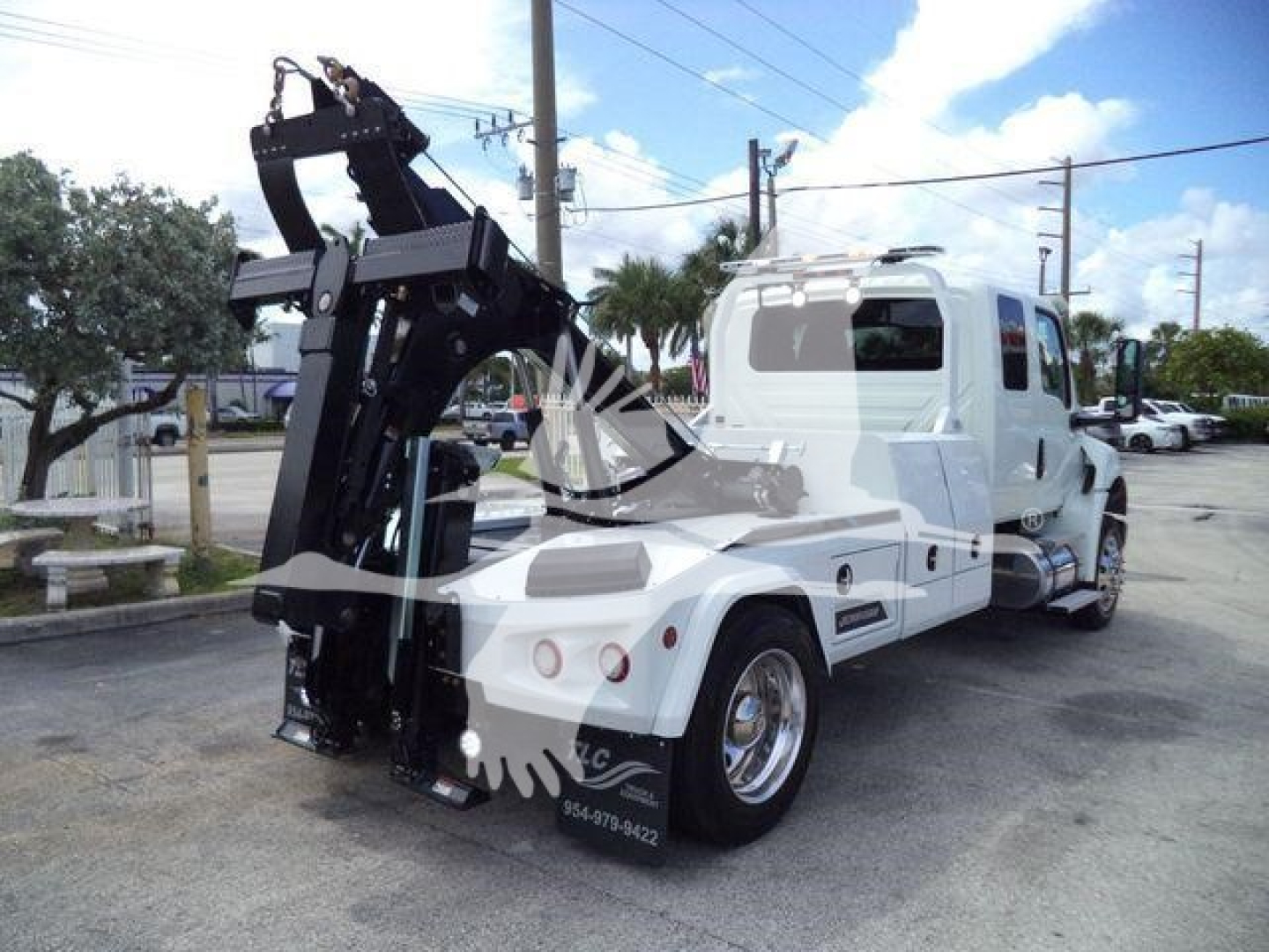 Truck showing integrated winch system and rear view with white cab and black winch assembly.