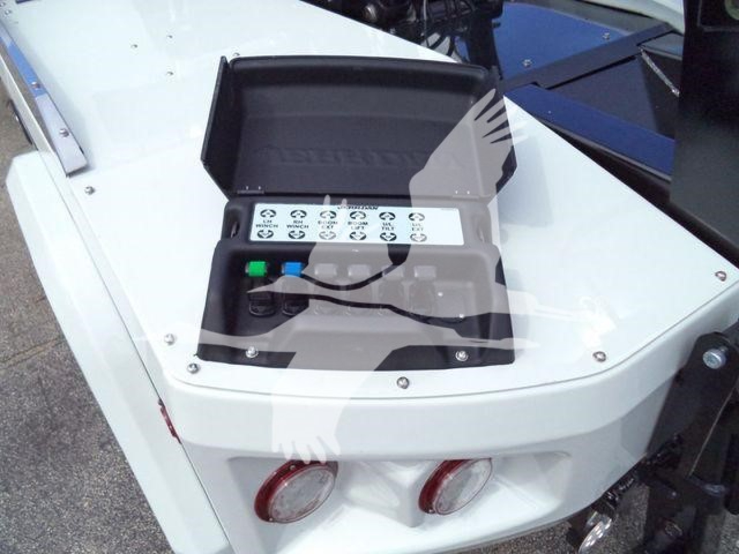 Winch control box on truck with illuminated buttons and labels; shows multiple circular symbols and green/blue buttons.