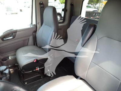 Truck cabin interior showing front seats and steering area in a new 2025 International MV winch listing.