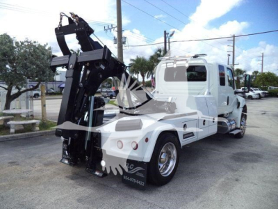 Truck showing integrated winch system and rear view with white cab and black winch assembly.