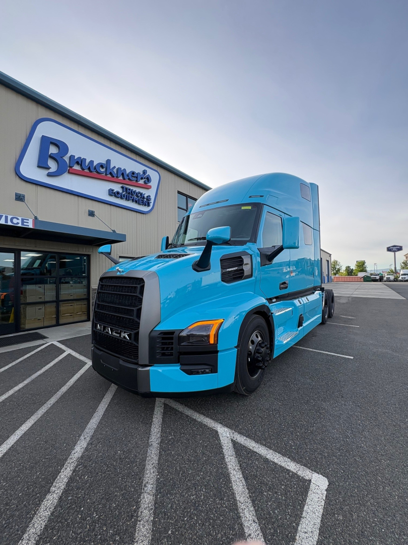 Mack PR64T76H truck in blue exterior parked outside dealership showing front grille and blue cab.
