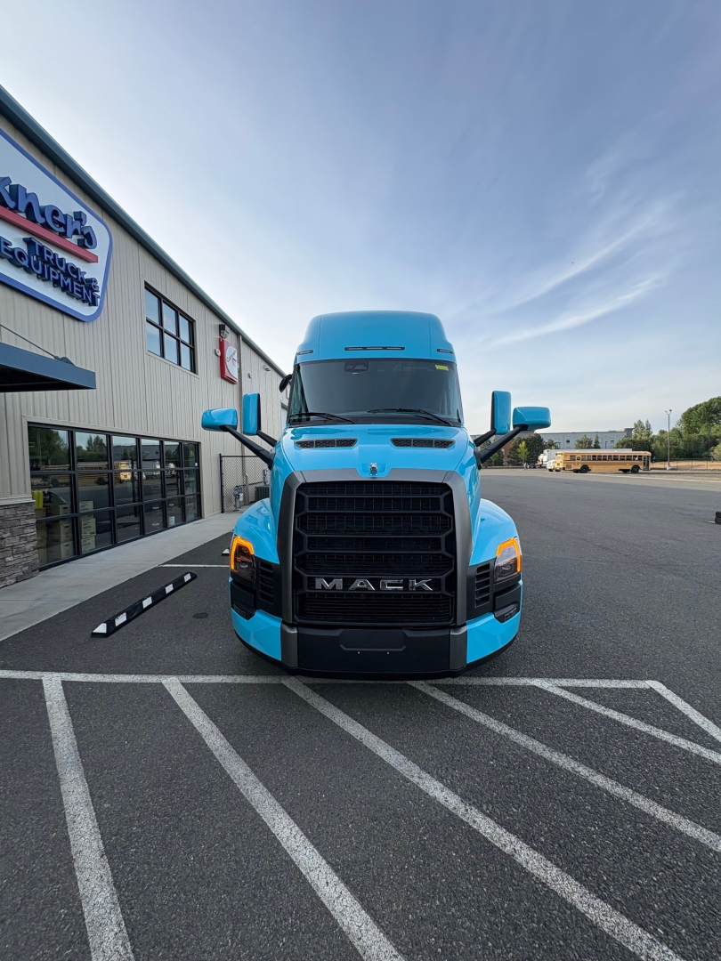 Mack PR64T76H conventional sleeper truck front view in blue, with large black grille and Mack logo visible.