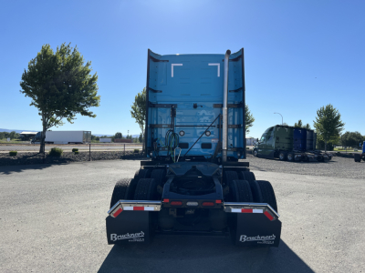 Truck rear view showing semi-truck fifth wheel and dual rear axles with mud flaps and Buckners branding.