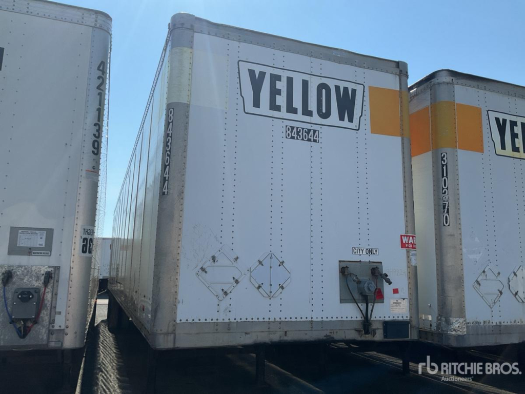 Trailer rear showing YELLOW label and safety decals on a box trailer.