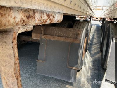 Trailer underside showing rusted frame and dual rear wheels with mud flaps under a Wabash trailer.