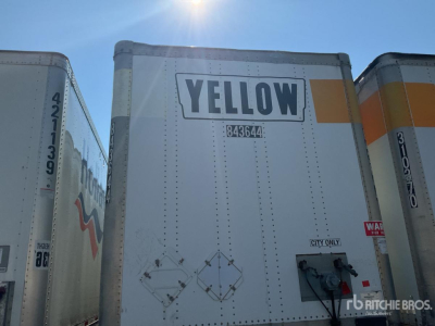 Trailer rear showing YELLOW logo and warning placards on a Wabash DVCVHPC trailer, with door hardware and safety decals visible.