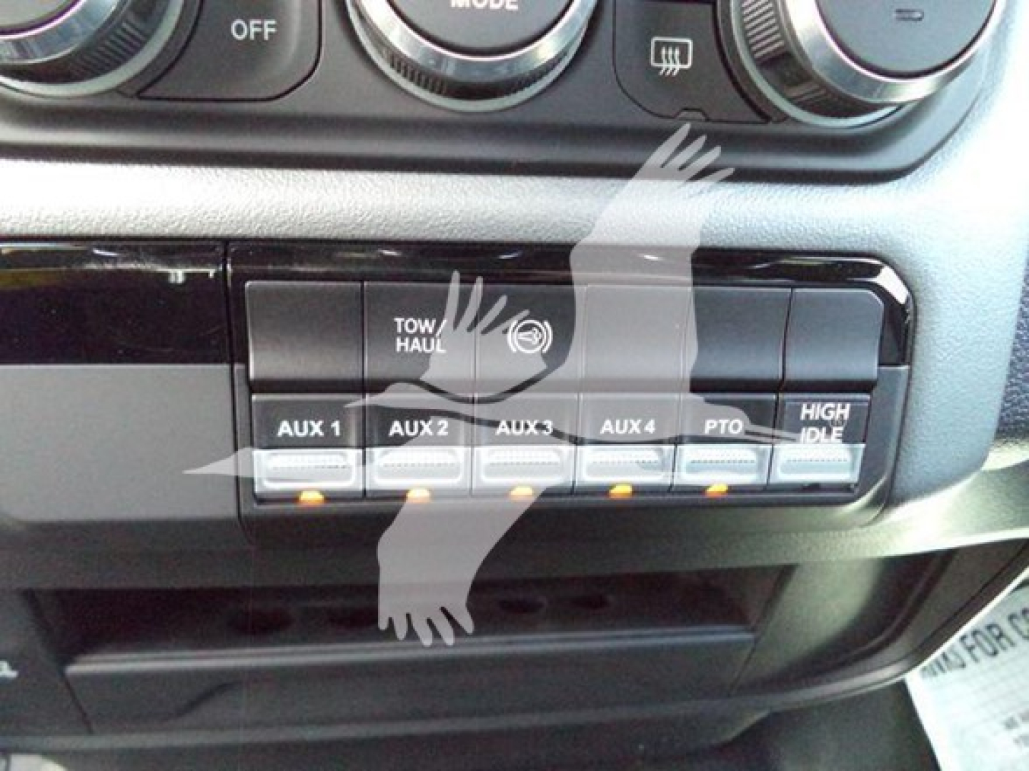 Ram 5500 dash area showing auxiliary switches labeled AUX 1 through AUX 4 and TOW/HAUL switch, with push buttons and control panel
