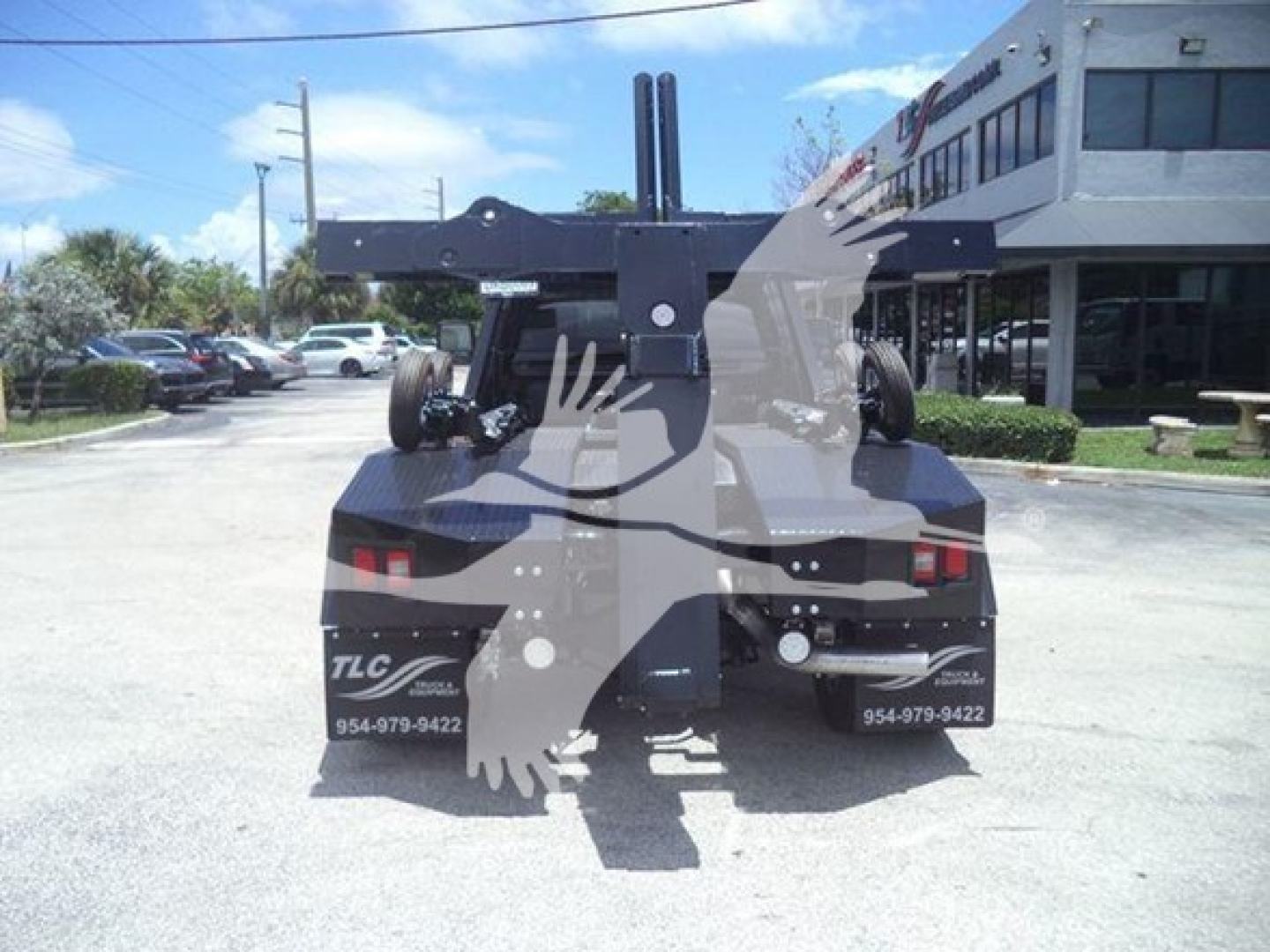 Ram 5500 truck rear with winch equipment and hitch, showing TLC branding and contact numbers on mud flaps.