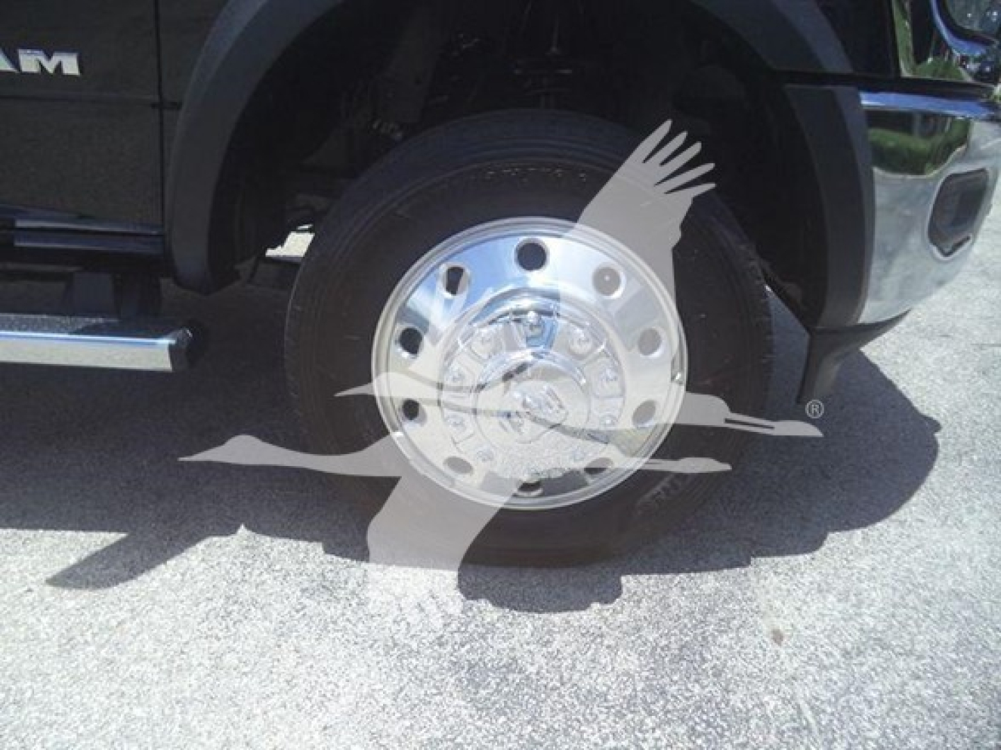 Truck wheel close-up showing chrome hub, black tire, Ram branding on fender; part of a Ram 5500 SLT pickup winch category vehicle.