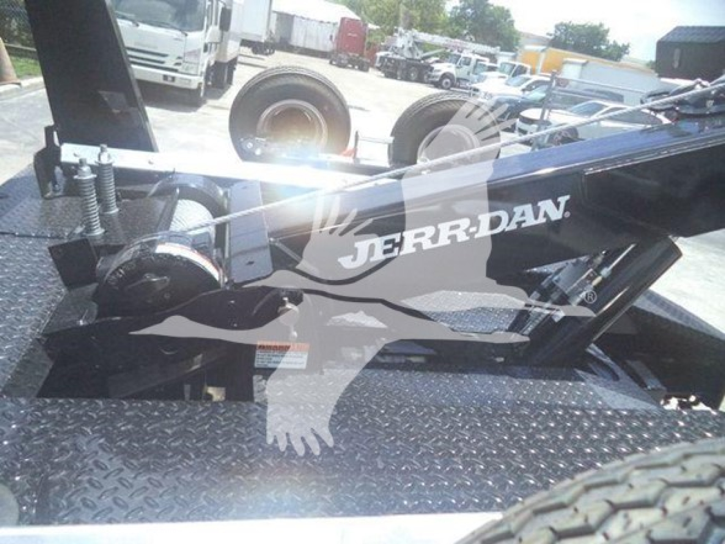 Ram 5500 winch setup with JerrDan logo on black metal frame and diamond plate bed; visible tires and industrial yard in background.