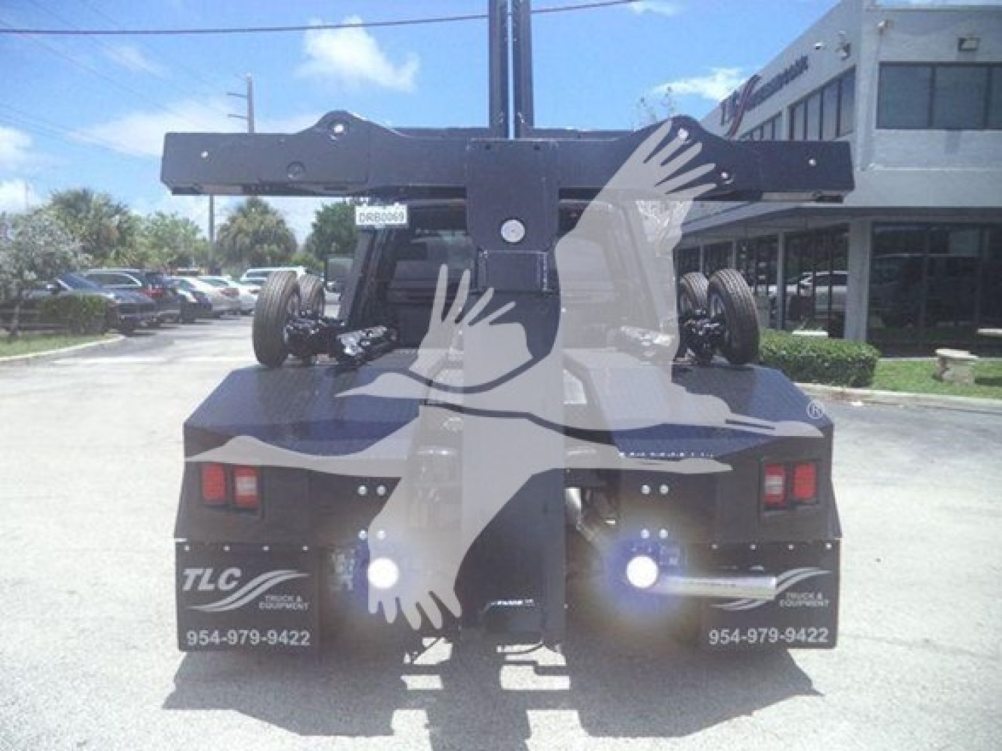 Ram 5500 tow truck rear view with winch mounting and hitch, dual taillights, bumper stickers, and blurred watermark over image.