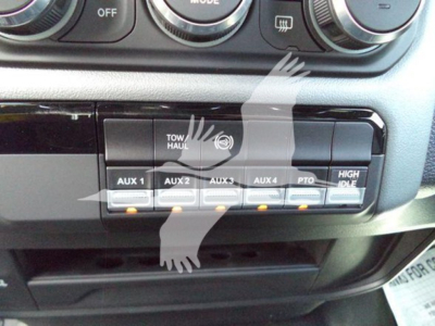 Ram 5500 dash area showing auxiliary switches labeled AUX 1 through AUX 4 and TOW/HAUL switch, with push buttons and control panel