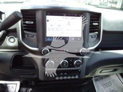 Ram 5500 dash showing large touchscreen infotainment display with climate controls below and various knobs. Partial steering wheel and dashboard.