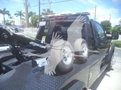 Ram 5500 SLT cargo bed with tow/haul equipment and spare tires; rear view shows winch truck bed and mounted mechanical components.