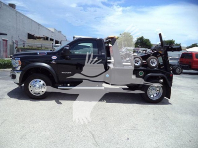 Ram 5500 SLT truck with winch bumper, black exterior, side view showing front chrome wheels and rear winch setup.
