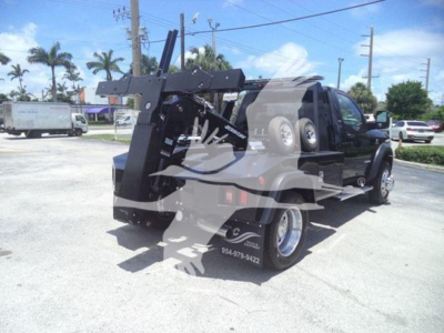 Ram 5500 tow truck with a winch and hoist in the bed, showing front and side views; visible markings include a winch mount and a dual rear wheel setup.