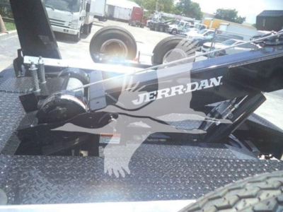 Ram 5500 winch setup with JerrDan logo on black metal frame and diamond plate bed; visible tires and industrial yard in background.