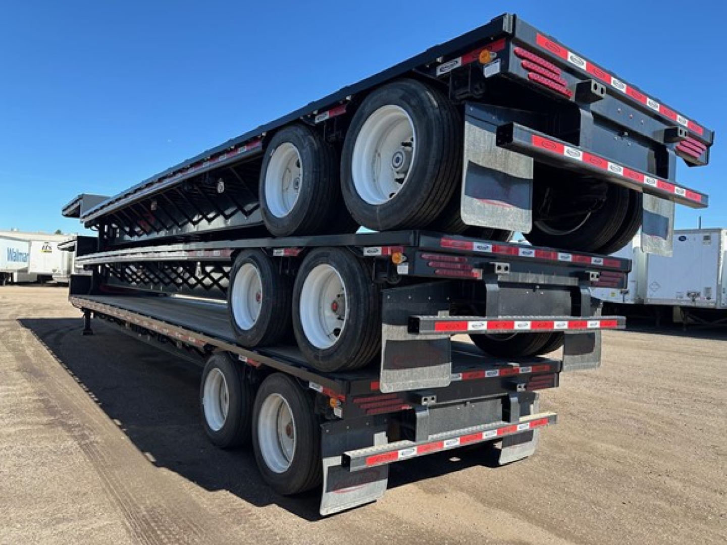 Trailer in stacked position showing multiple axles and wheels on a drop deck trailer.