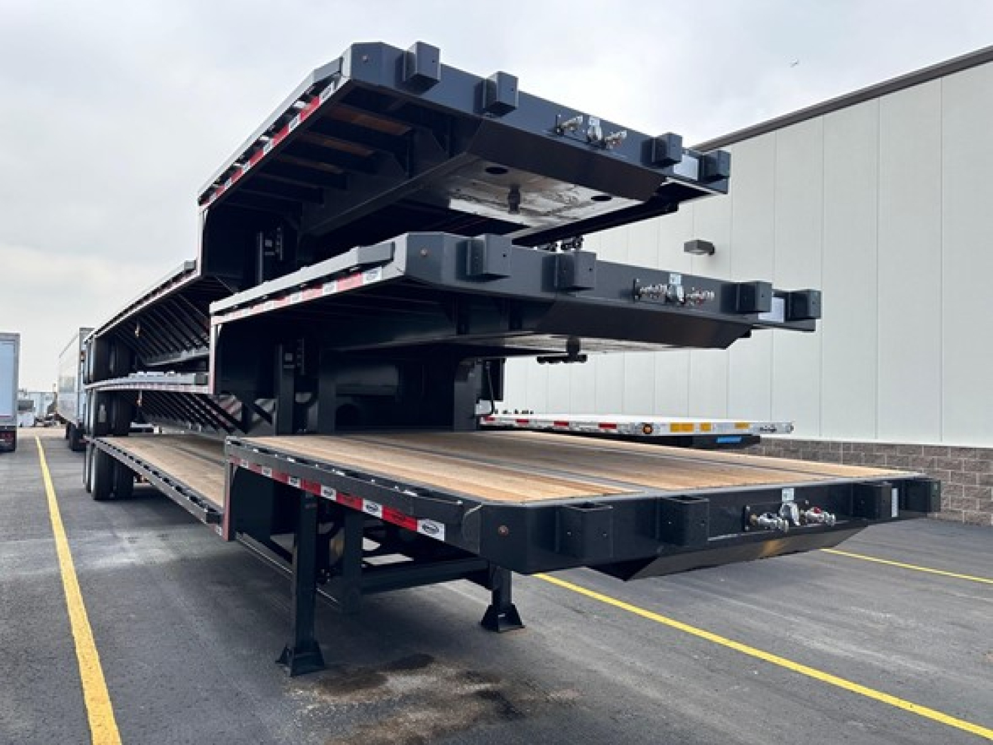 Trailer bed with stacked drop deck trailers showing steel construction and multiple levels in a loading yard.