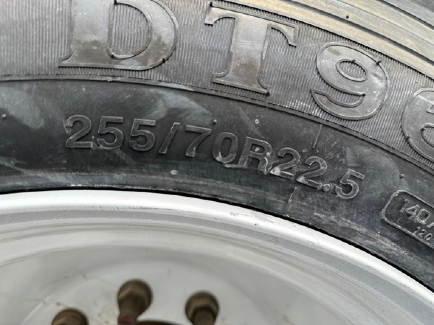 Trailer tire with visible markings 255/70R22.5 on sidewall and wheel rim; close-up shot from a Dura Haul closed tandem steel drop deck trailer.