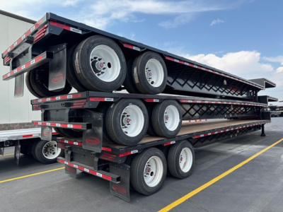 Dura Haul closed tandem steel drop deck trailer stacked three high with wheels and deck ramps visible