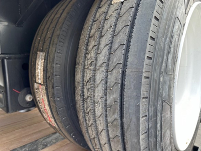 Tire and wheel assembly of a trailer showing dual tires with tread pattern and sidewall markings.