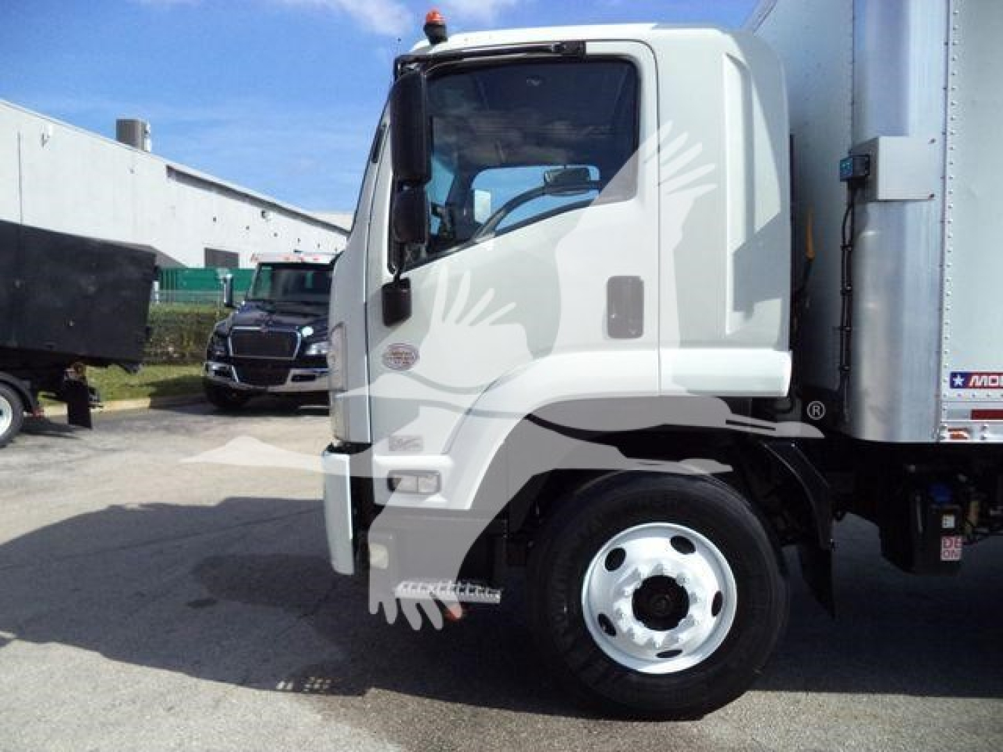 Isuzu FTR cab and box truck side view showing front wheel and cab doorway.