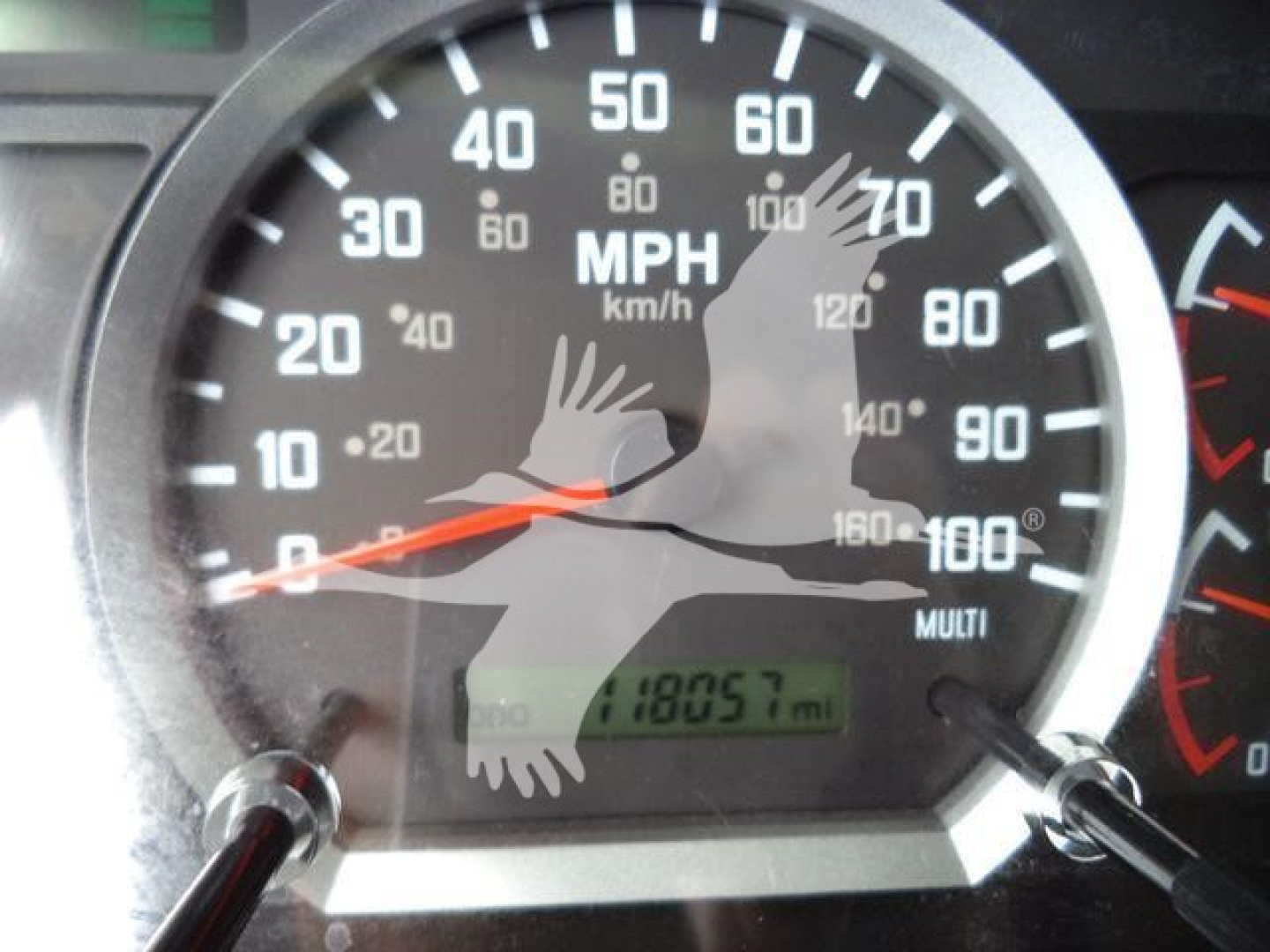 Instrument cluster and speedometer of Isuzu truck showing 0-100 mph scale with odometer reading 18057 miles.
