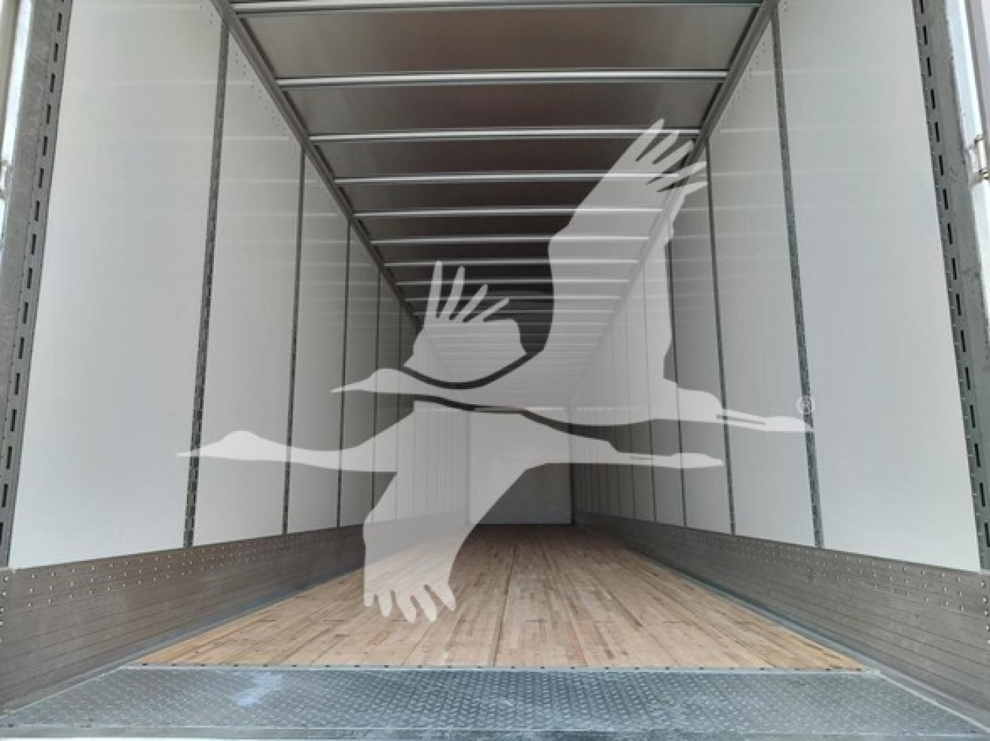 Inside cargo trailer showing empty box with wooden floor and metal sidewalls.