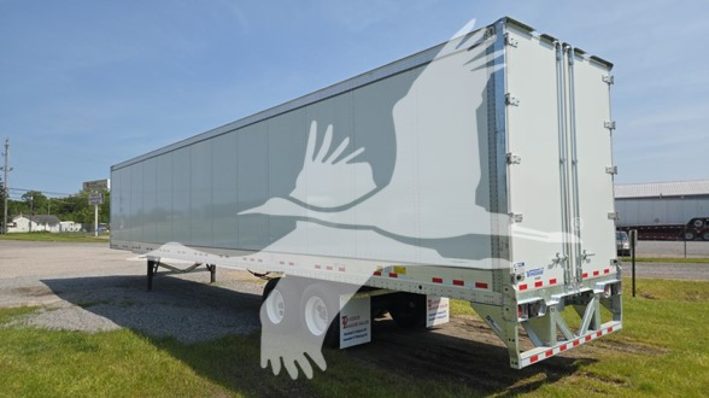 Trailer side view showing Vanguard VXP-High Base Rail logo and white graphic artwork, rear doors, tandem axles, reflective tape, and support legs.