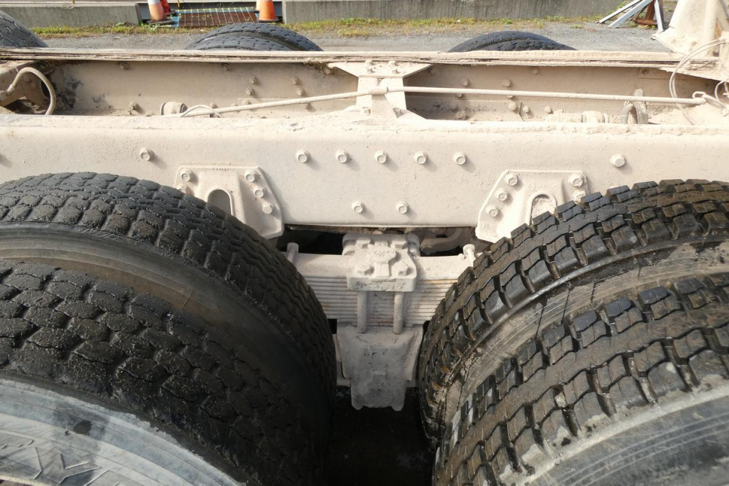 Peterbilt truck chassis showing dual rear wheels and frame crossmember with riveted components.