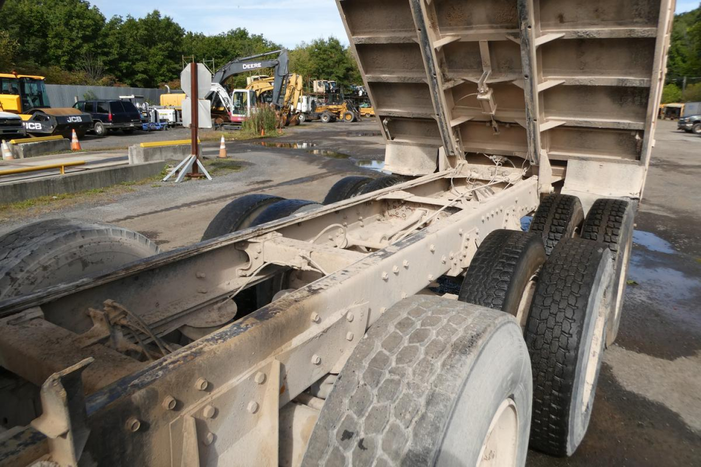 Peterbilt 357 dump truck chassis and dual rear axles with raised dump bed, showing metal frame and tires.