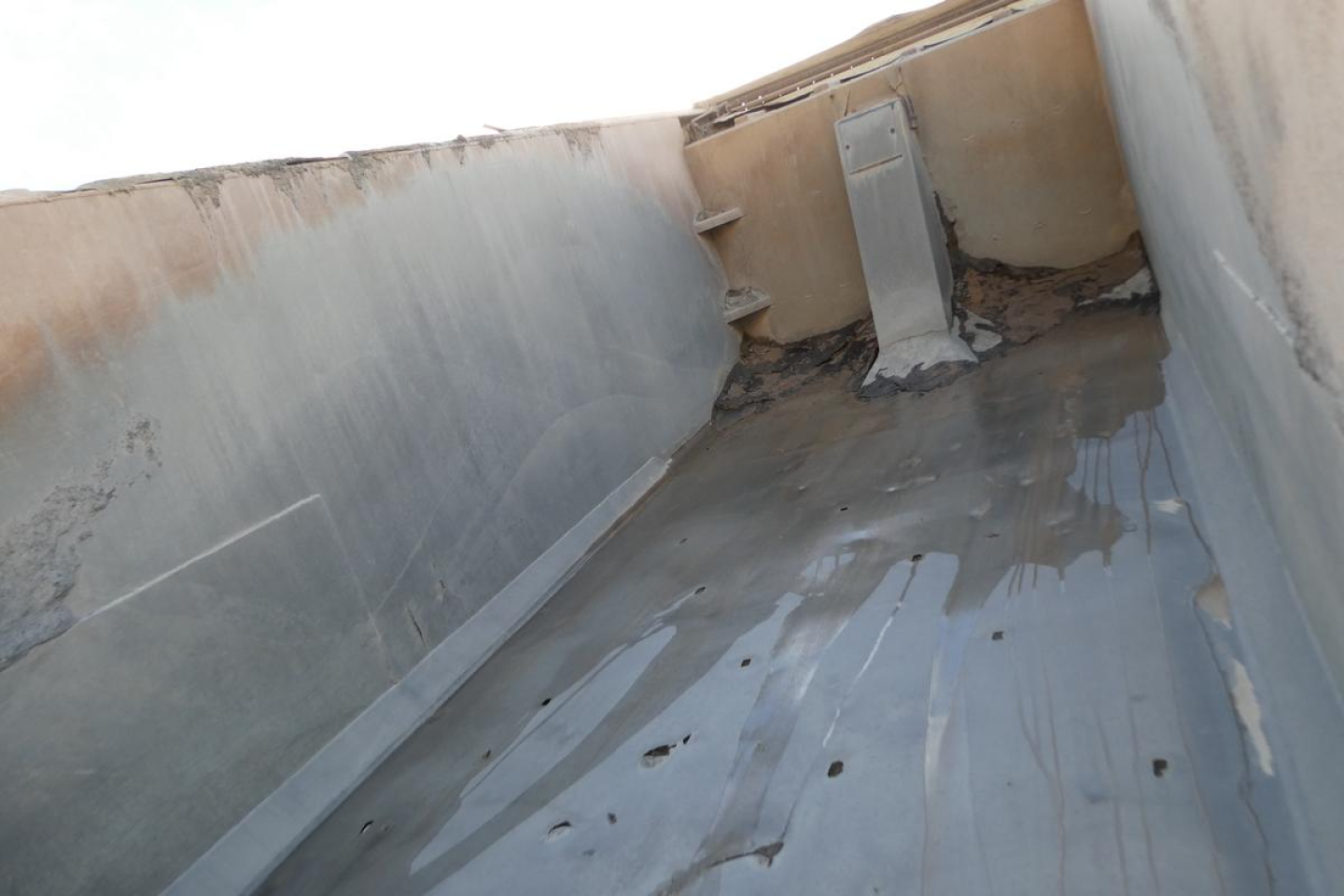 Truck bed interior showing metal walls and a flat floor with some residue