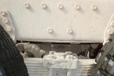 Peterbilt 357 dump truck undercarriage showing suspension leaf springs and axle near the wheel well.