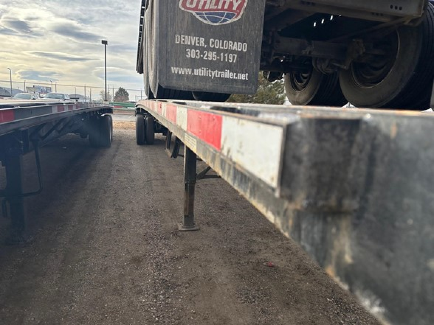 Flatbed trailer deck with Fontaine Velocity tag showing Utility trailer center branding and Denver, Colorado contact info.