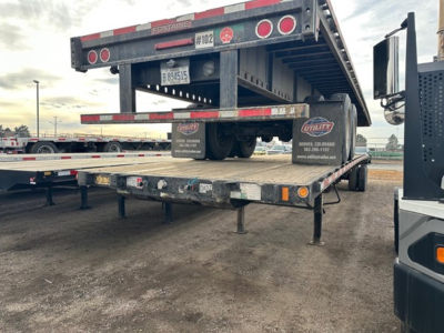 Flatbed trailer with Velocit y Fontaine Velocity steel flatbed showing rear section and support legs. Trailer bumper and undercarriage visible.
