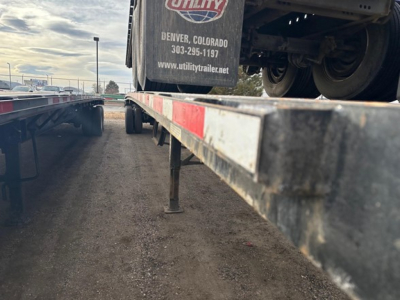 Flatbed trailer deck with Fontaine Velocity tag showing Utility trailer center branding and Denver, Colorado contact info.