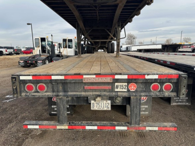 Flatbed trailer rear showing Fontaine brand, taillights, bumper, license plate, and #152 markings.