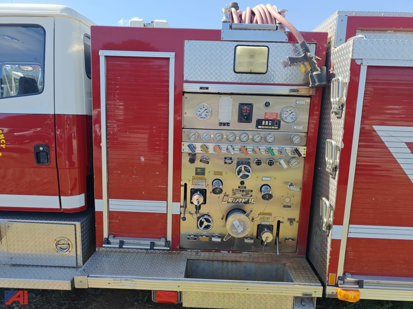 Firetruck control panel on a red firefighting compartment with gauges, switches, and knobs visible.