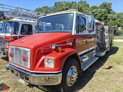 Firetruck 2001 Freightliner FL80 in red with chrome bumper and wooden side panels, emergency lights on cab, ladder rack, and compartments on the side.