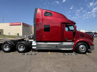 2021 Peterbilt 579 truck cab with red exterior, side view showing sleeper cab, VIN 1XPBDP9X9MD748992 on paperwork, stock 0627706, Kenworth building in background, conventional sleeper tractor