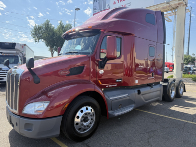 Peterbilt 579 semi-truck in maroon showing side view with sleeper cab and dual rear axles.