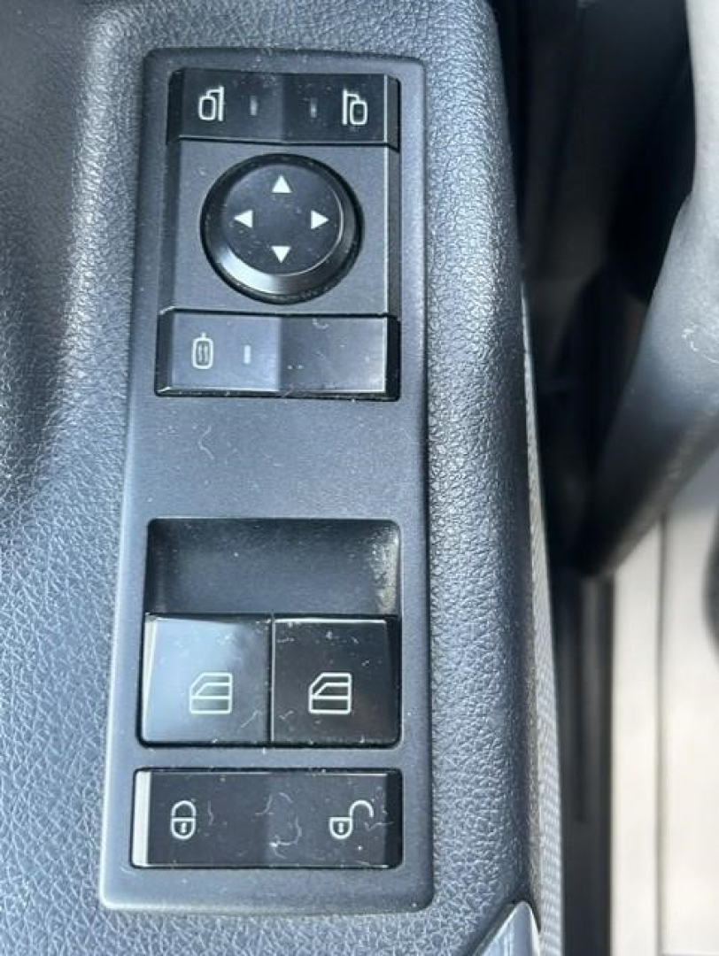 Truck interior control panel with window lock and mirror adjustment switches on left door of a 2021 Freightliner Cascadia 126.