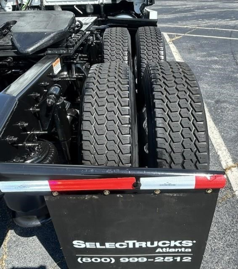 Semi truck tractor rear wheels and chassis showing dual rear tires and freightliner components. Visible text reads SELECTRucks Atlanta (800) 999-2512 on a black rear panel.