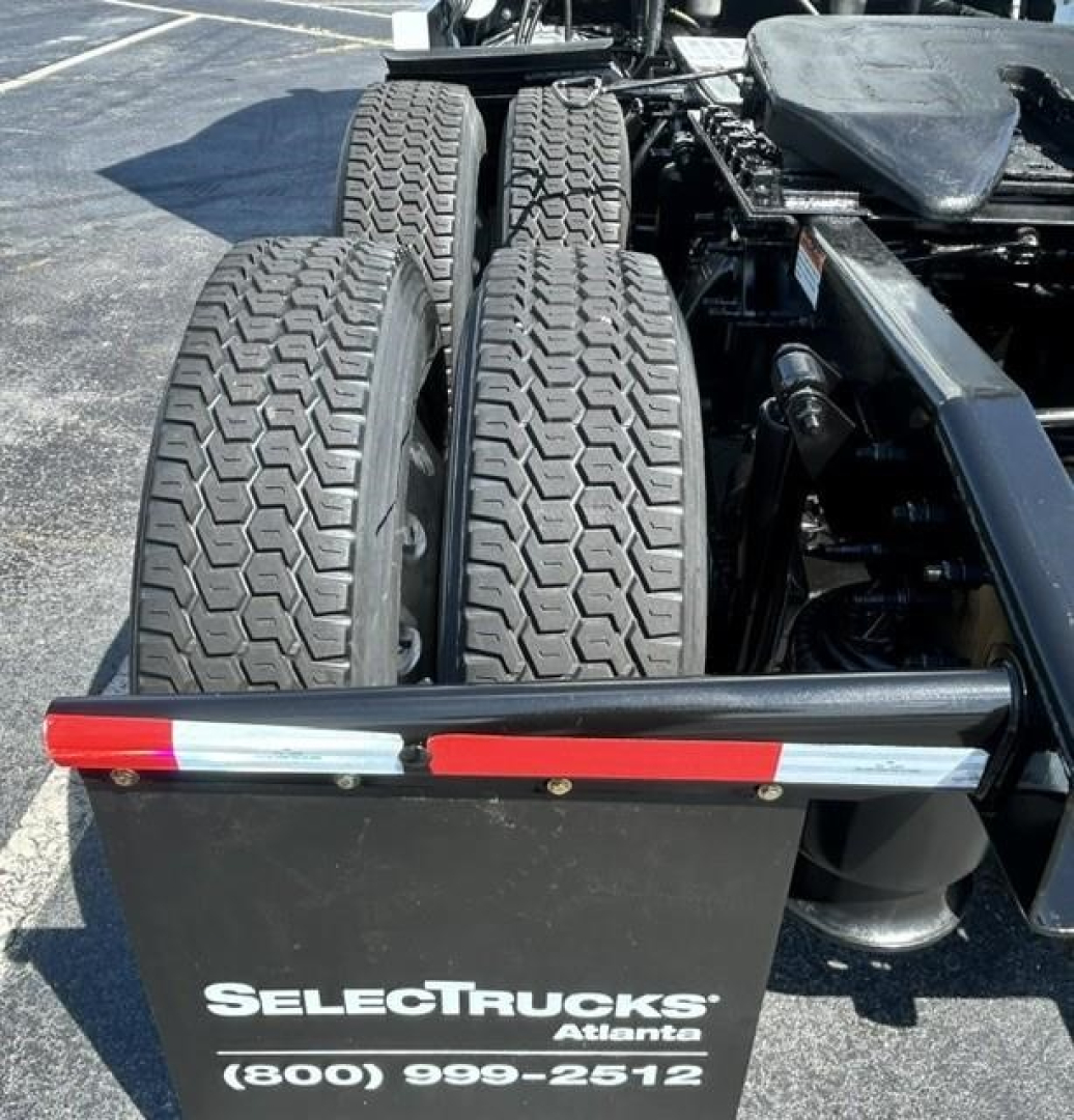 Rear view of a Freightliner Cascadia tractor showing tandem rear axles and dual tires with a SelectTrucks Atlanta logo plate.