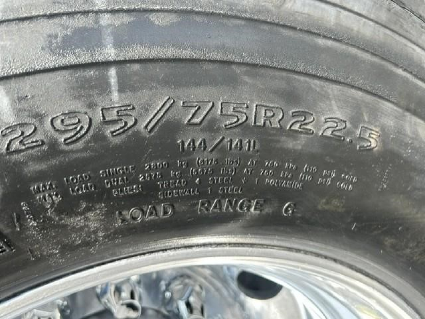 Tire with marking 295/75R22.5 showing load range indicating tire specification and sidewall type.